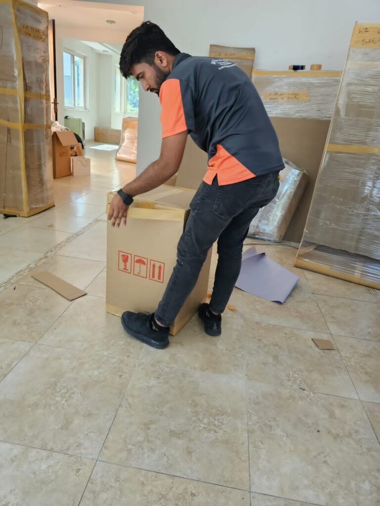 Professional movers and packers handling items in Business Bay, Dubai, with workers carefully packing and organizing household goods for relocation