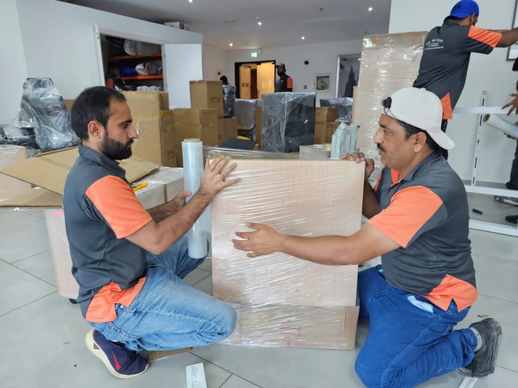 Experienced movers and packers efficiently packing and transporting items in Palm Jumeirah, Dubai, with workers carefully handling furniture and belongings for relocation